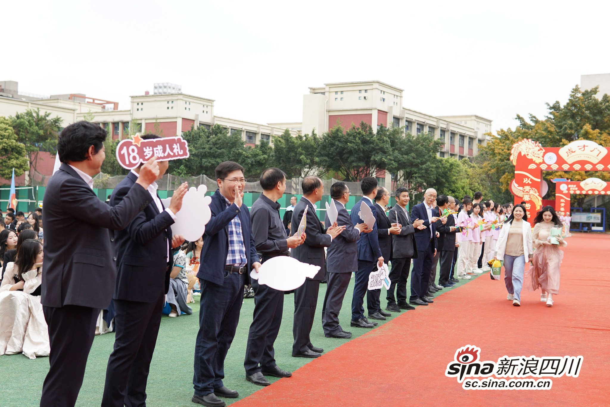 高新实验中学校领导、老师在红毯两边为高三学生加油