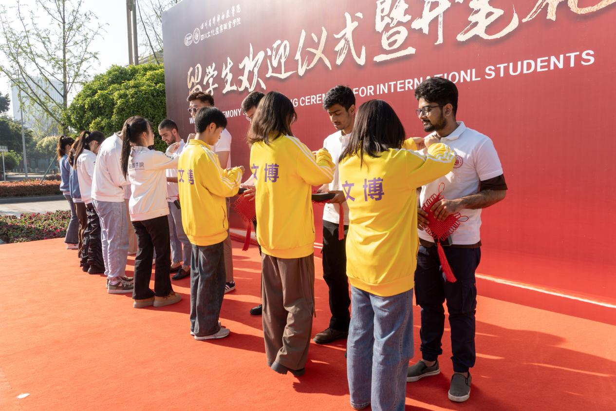 为留学生佩戴校徽并赠送学习礼品