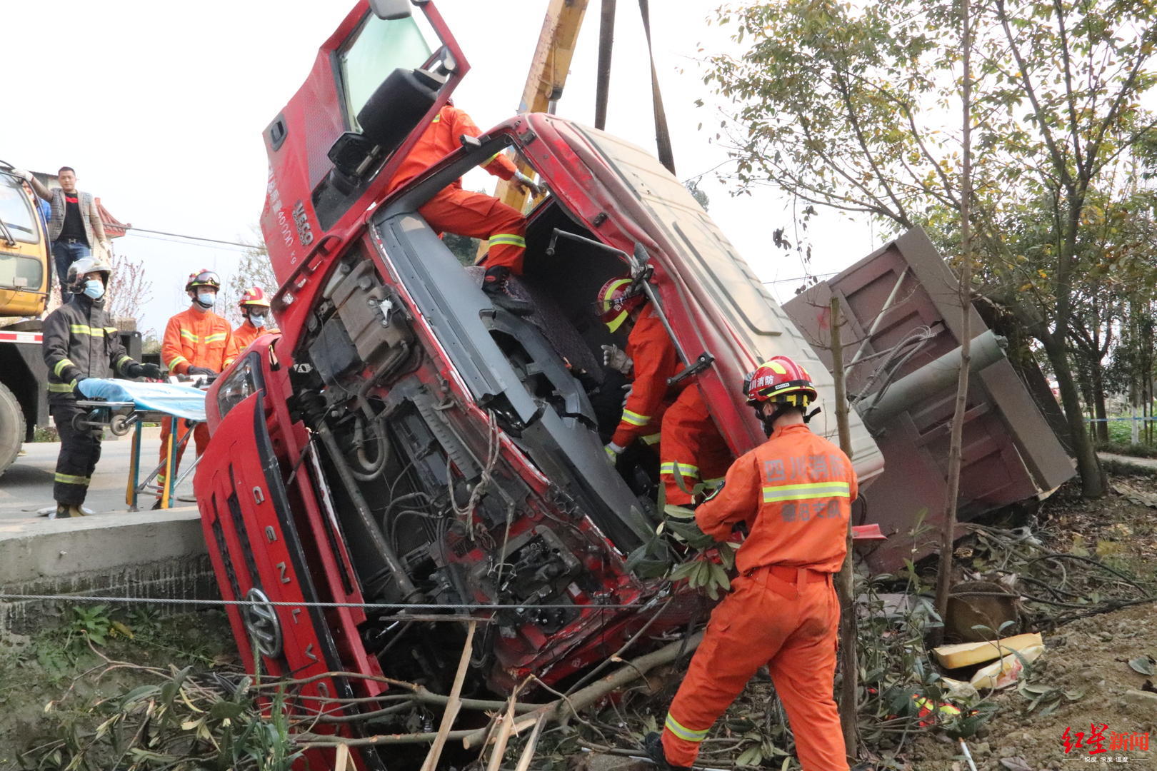 吊车救援!货车与中巴相撞后翻下马路 驾驶室变形司机被困