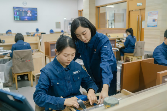 四川中烟长城雪茄厂手工车间卷制大师李秋月(右)正在对团队成员进行指导。四川中烟工业有限责任公司供图
