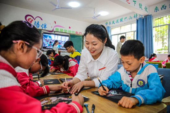 借力浙川东西部协作，建立了留守儿童周末假日寄宿学校，图为学生正在老师指导下学习绘画