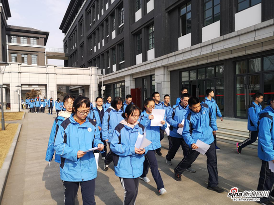 突然从公园的入口处走来一批队伍,他们身着成都二十中校服,手拿工具