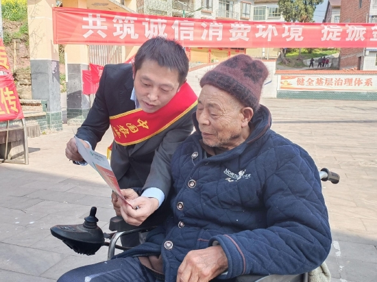 農(nóng)行達州分行工作人員在宣漢普光花石村現(xiàn)場給一老年村民宣講防電信詐騙知識
