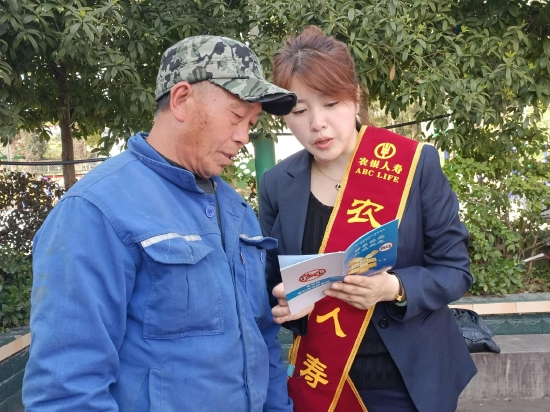 農(nóng)銀人壽達州中支工作人員在宣漢普光花石村現(xiàn)場向一村民宣傳消費者權(quán)益保護知識