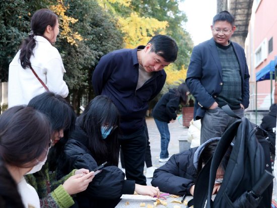 嘉宾饶有兴致地参观学生绘制青春健康主题书签