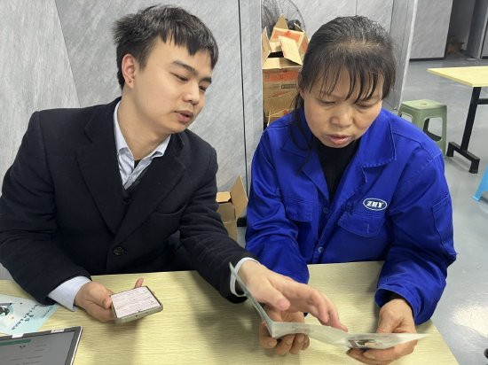 图为农行开江支行“金融卫士”宣讲团成员正在给工人讲解知识