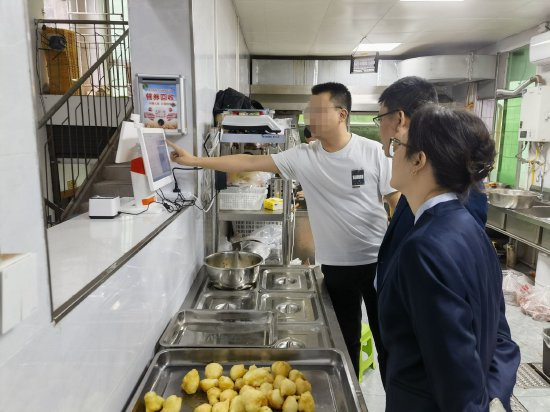 图为农行员工现场指导培训食堂工作人员使用操作“智慧食堂数字化系统”