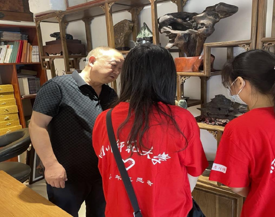 第三代传承人彭耘在和团队介绍“雾山石刻”作品