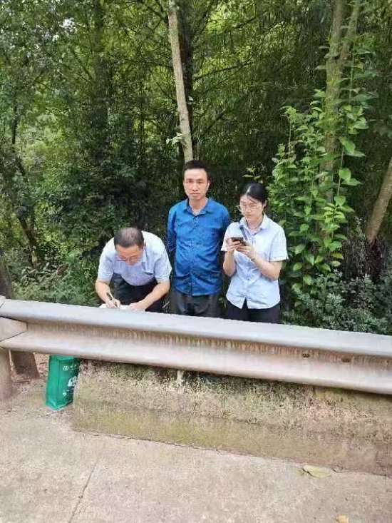 图为农行万源支行员工在草坝李家梁水库项目工地旁为一工人办理开卡业务