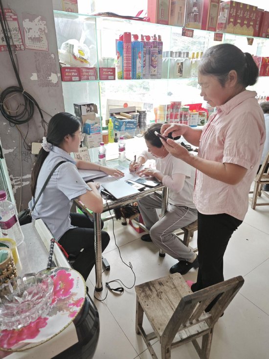 图为农行万源市支行工作人员在为一客户经营现场提供服务