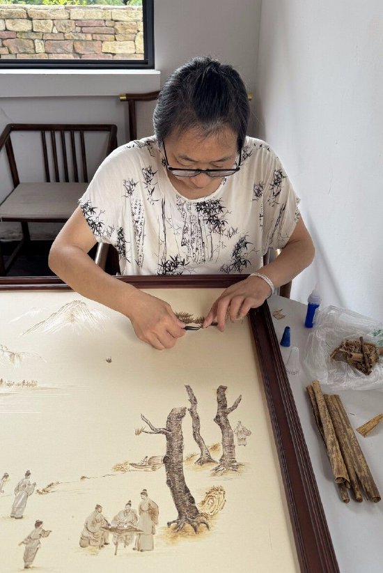 李学琴正在用笋壳作画