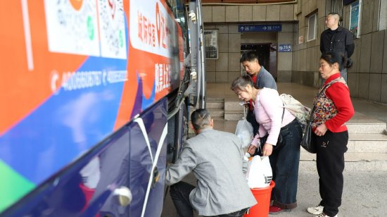 工作人员正在帮助乘客安放行李