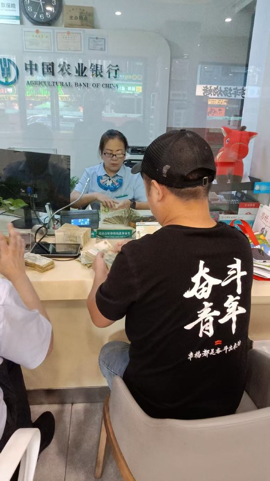 图为郑莲在整理客户残湿零钞