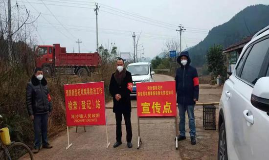 图为:河沙镇桂花村文明实践站志愿者在出入口卡点值班轮守