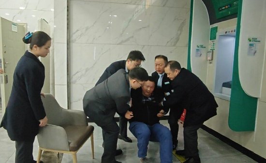 图为农行达川支行男性员工合力救助客户