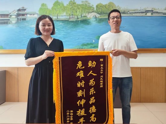 以为济南章丘市民带着一面"助人为乐品德高,危难时刻伸援手"的锦旗