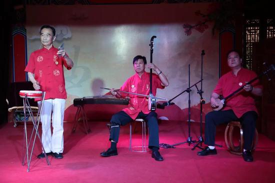 旅游频道 > 正文  在谢裕大茶行李明治正在表演河洛大鼓.