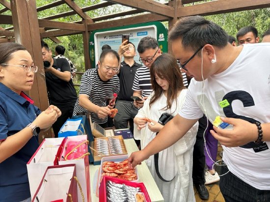 图:大V们在水语小镇品尝特色农产品