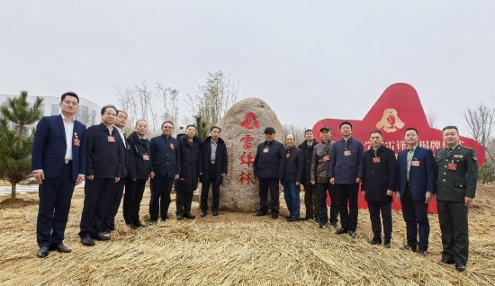 雷锋班14任班长与青岛黄海学院副校长孟广东在雷锋林石碑前合影