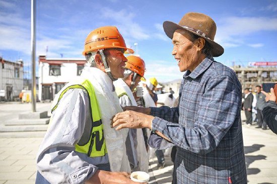 7月1日，在日喀则市定日县森嘎村“感恩广场”，村民向援建者献哈达。新华每日电讯记者陈浩明摄