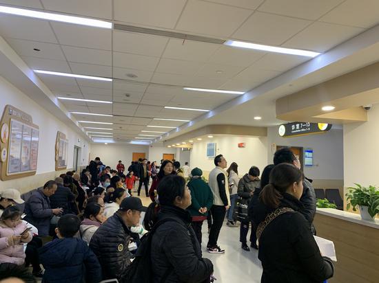 在上海儿童医学中心儿内科门诊候诊区,家长陪同患儿前来就诊.