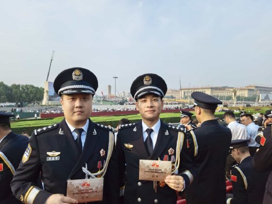 　　上海市公安局网安总队民警肖荒拓（左）、黄浦分局交管支队副大队长黄俊（右）作为民警代表，受邀参加了天安门广场的现场观礼。 上海市公安局 供图