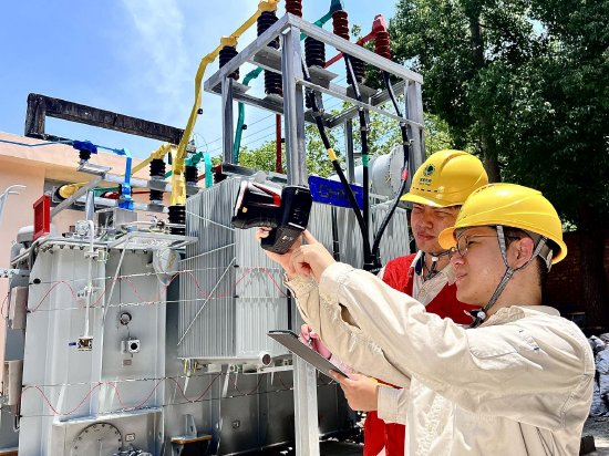 　　7月14日，国网上海市区供电公司运检部变电运维一班班员龚卜文、张奕成在杨浦区35千伏彰武站，使用红外线测温仪对室外主变的绝缘子进行检查，全力确保高温天气设备运行正常。（刘佳凤）