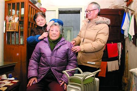 张福根,王顺娟夫妇为朱荣英梳头按摩.