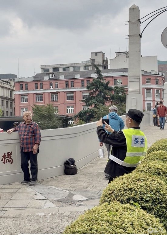 为市民拍照的保安。施晨露摄