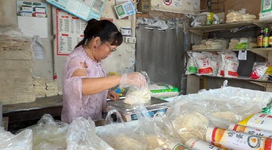 　　积水退后，上海金山区吕巷镇干巷菜市场，经营户杨阿姨正把米面一摞摞码齐。 “i金山”微信公众号 图