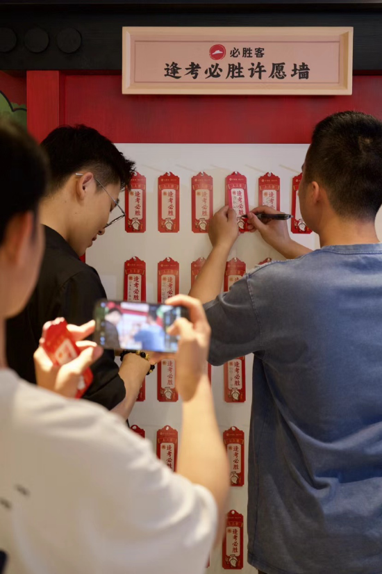 消费者在上海“逢考必胜”主题餐厅内与“许愿墙”互动