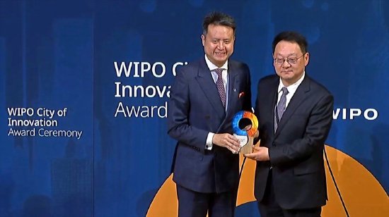 上海市政府副秘书长周亚明（右）从世界知识产权组织（WIPO）总干事邓鸿森手中接过创新城市奖杯。
