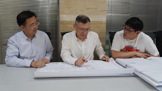 龚存忠(中)与团队研讨技术方案。中国船舶集团第七〇四研究所供图