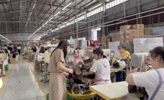 邱敏在工厂与工人沟通