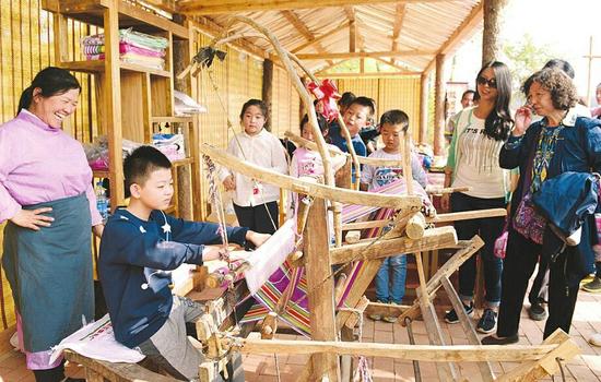 游客在山西临汾乡村景点体验织布技艺(图)