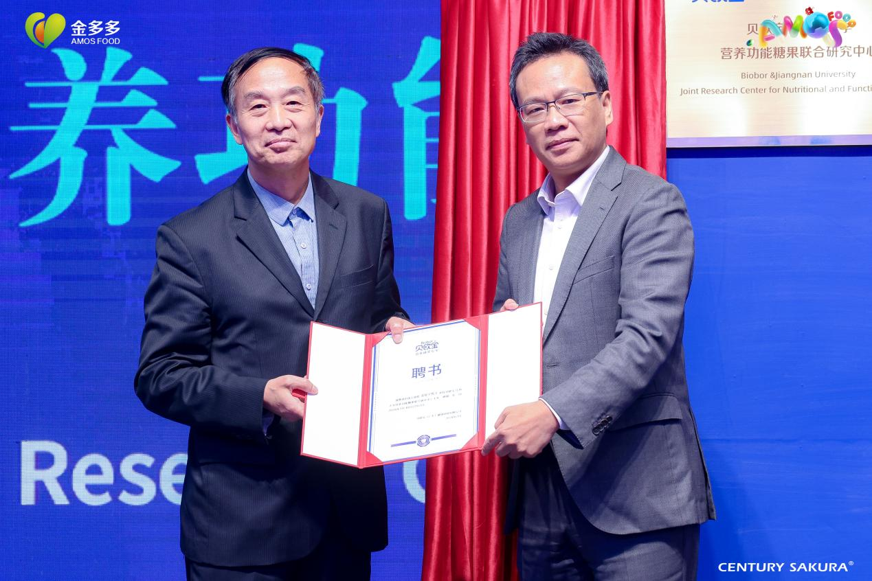 (图为金多多与中国工程院士、江南大学教授金振宇共同建立贝欧宝“营养功能糖果”联合实验室)