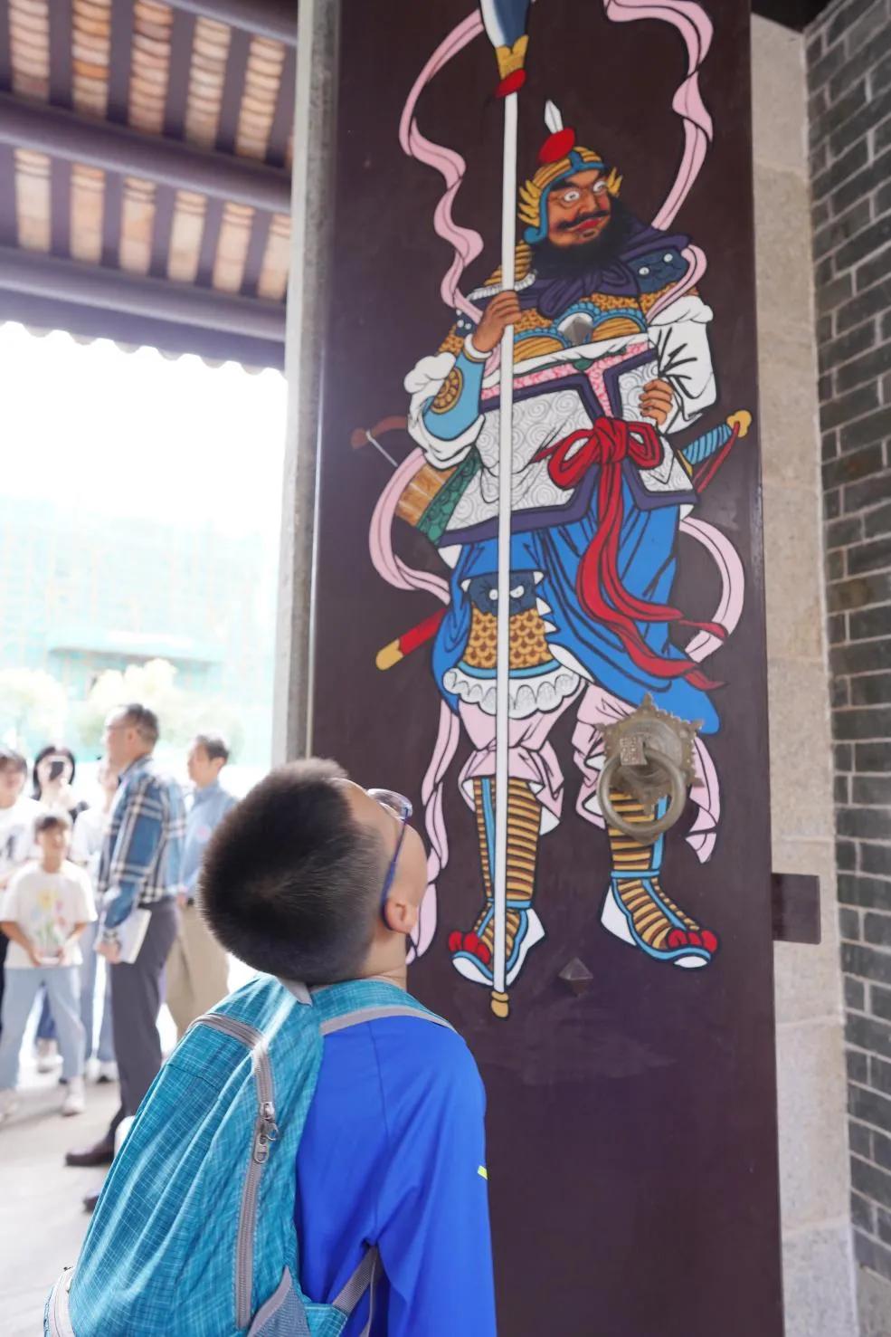 小读者欣赏祠堂的门神画像。