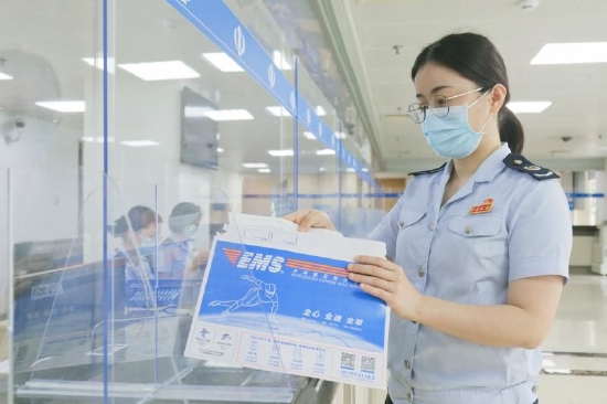 “龙税云”集约办理中心税务人员正在处理代开发票邮寄业务