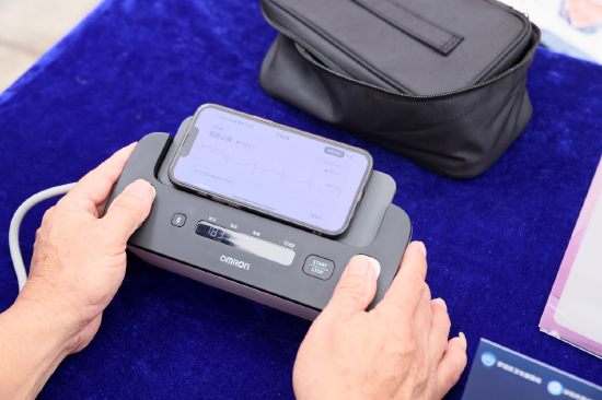 义诊活动现场，居民积极体验欧姆龙心电血压计