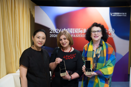 　　品牌创始人梁云侠与设计总监儿子许家煜向多国夫人赠送与南山区残疾人联合会深度公益合作的香云纱饰品。