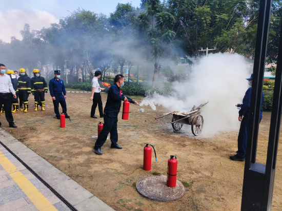 小区物业工作人员正在指导员指导下参与模拟灭火