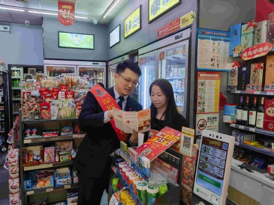 银行工作人员上门给商铺开展拒收人民币现金专项整治工作宣传