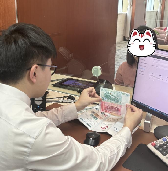 在柜台向市民宣传科普假币识别小技巧