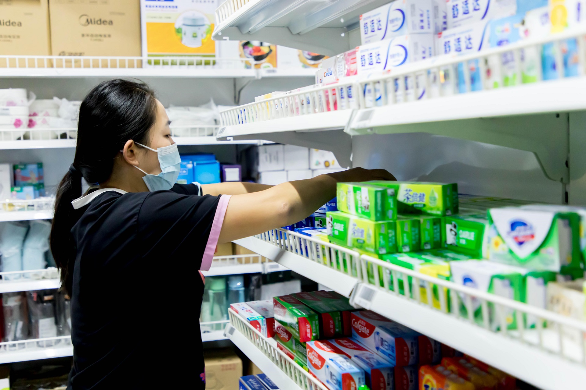 一家便利店内,营业员正在分拣商品.摄影:李鸣