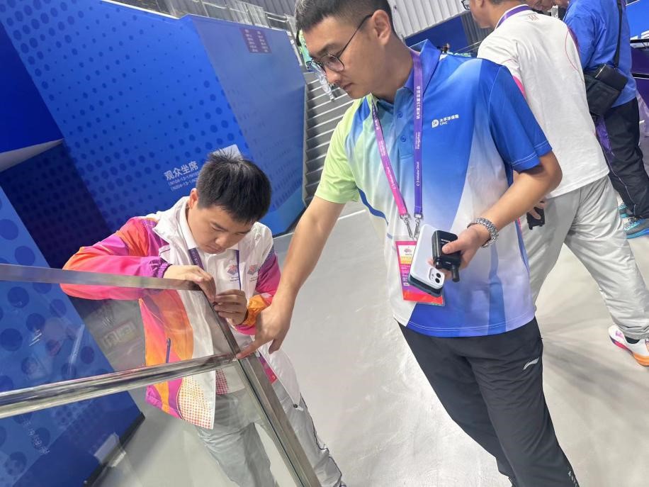 崔钟元(左二)协助场馆处理楼梯金属边框