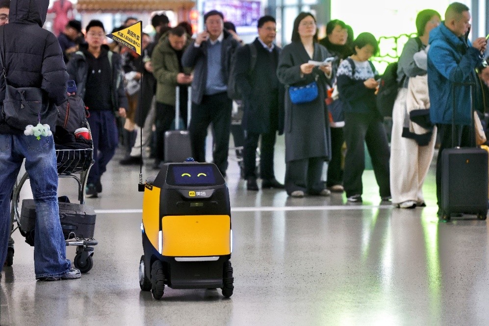 ▲美团“小黄蜂”在人流中穿梭配送外卖（管乐 摄）