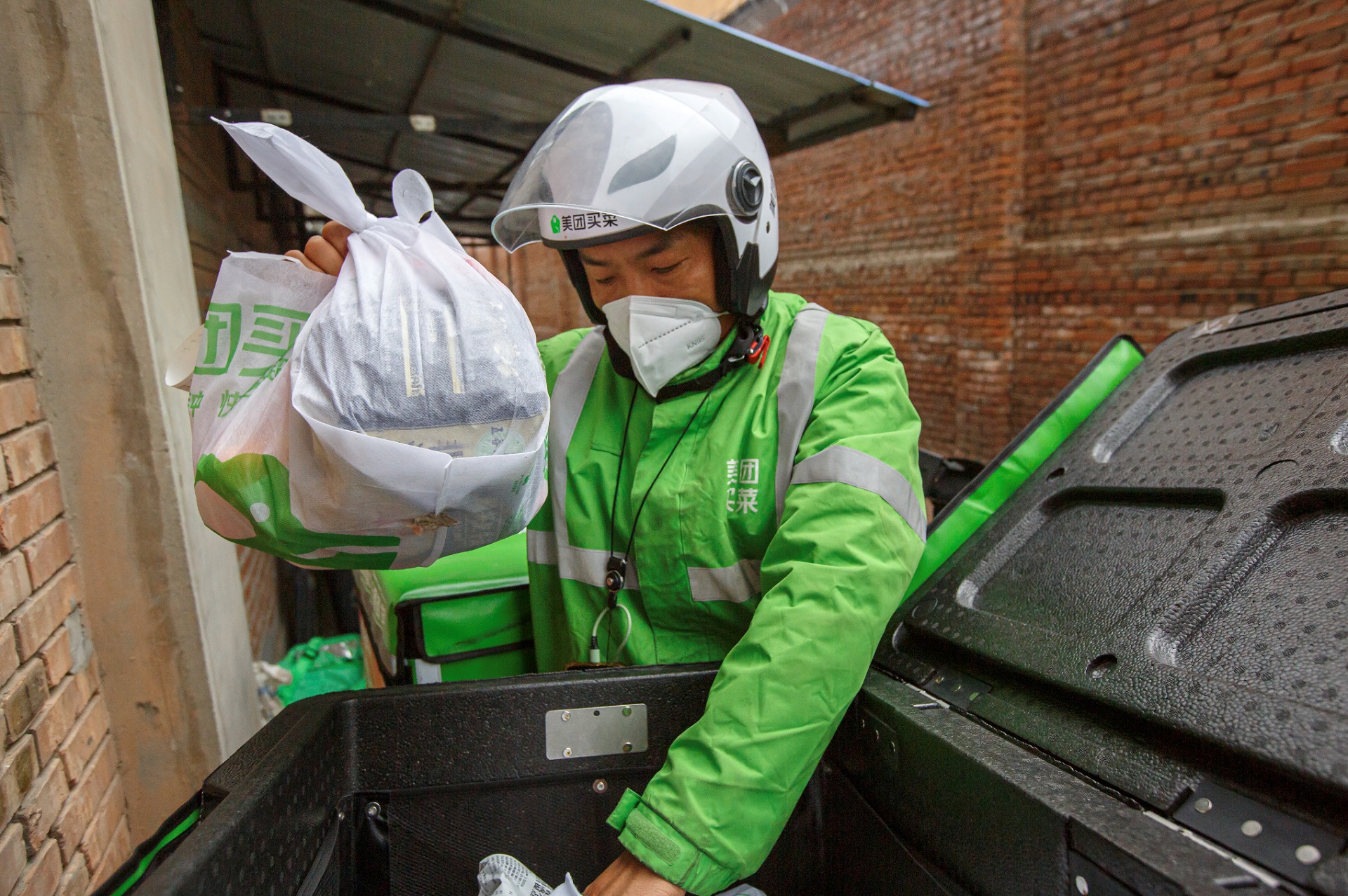 2022年疫情期间,美团买菜骑手正在配送商品.拍摄:王飞