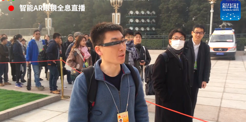 (新华社记者在会场外佩戴ar眼镜进行直播)