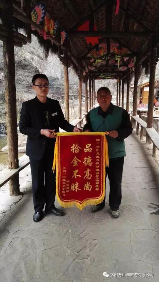 环卫工张莫收从园务部工作人员手中接过锦旗