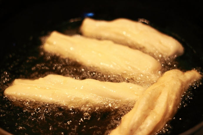 油的温度要烧到8成热或以上才行,温度没达到时,炸出来的油条不蓬松4